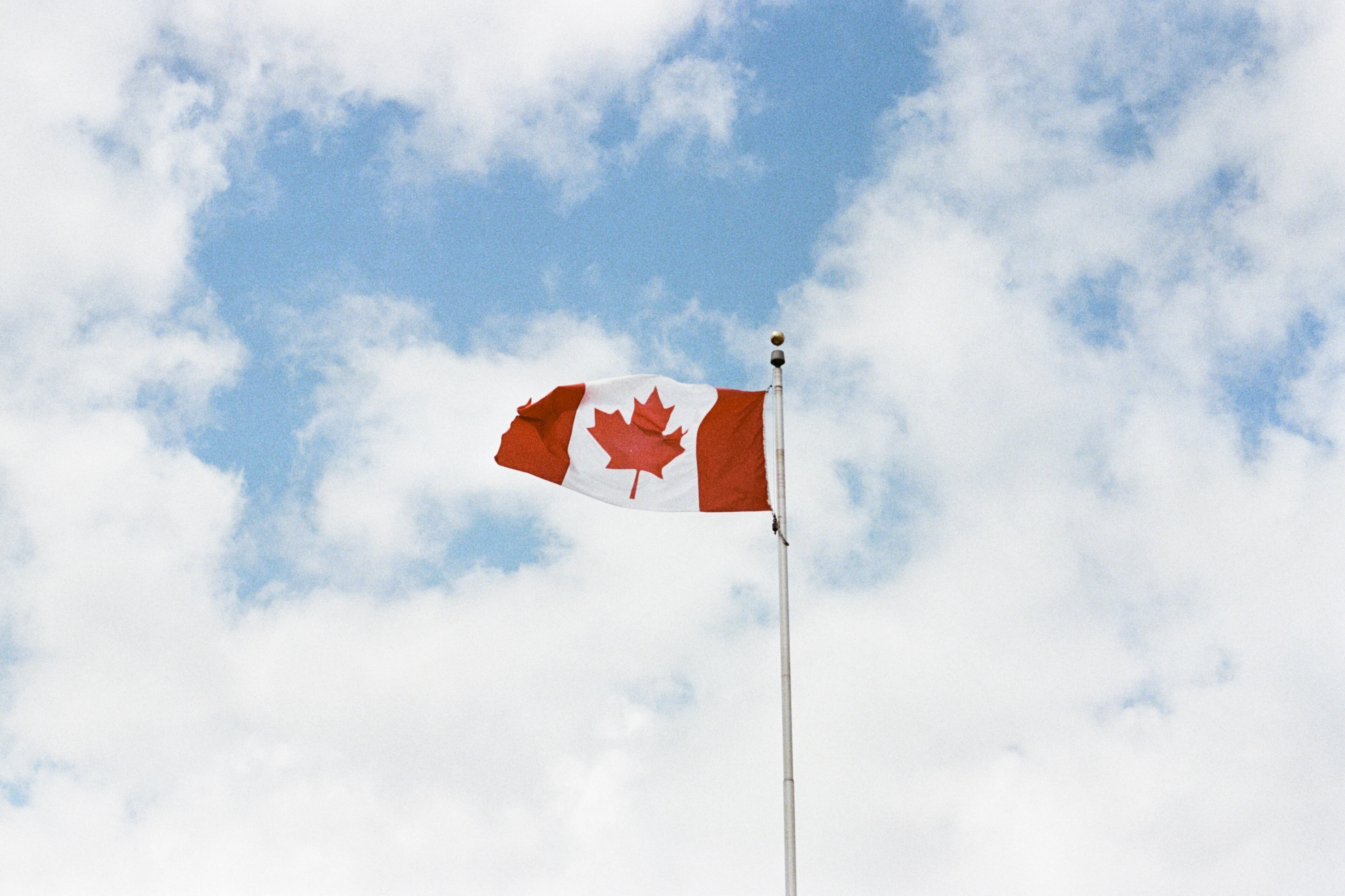 canadian-flag-against-cloudy-sky.jpg